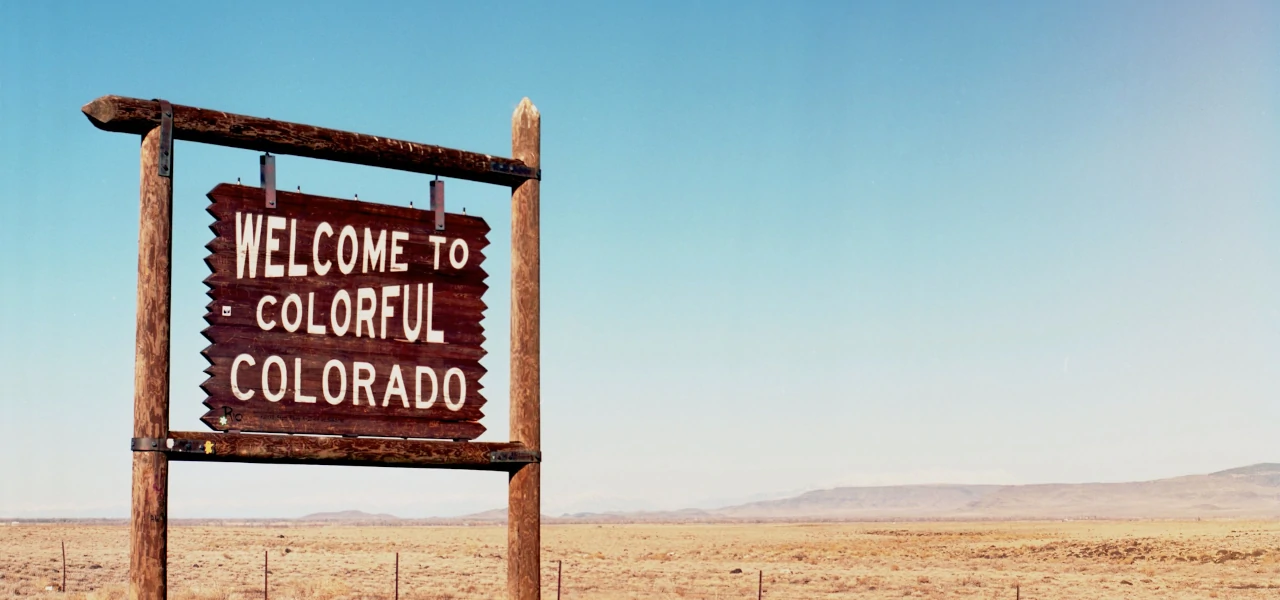 A wooden sign saying "Welcome to colorful Colorado"